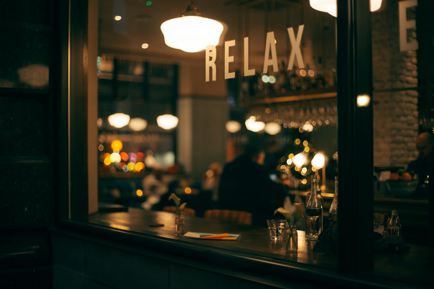 Een terras op straat in het centrum, warm verlicht in de avond — de sfeer rond de Laat